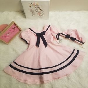 This is a very adorable pink and black dress it comes with a little hat